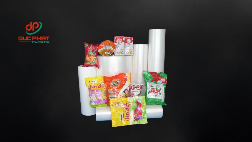 ứng dụng thực tế của màng PE trong đóng gói công nghiệp và bảo quản thực phẩm hàng ngày. Cuộn màng PE đặt cạnh các sản phẩm đóng gói như snack, thực phẩm, cho thấy vai trò bảo vệ và bảo quản hàng hóa.